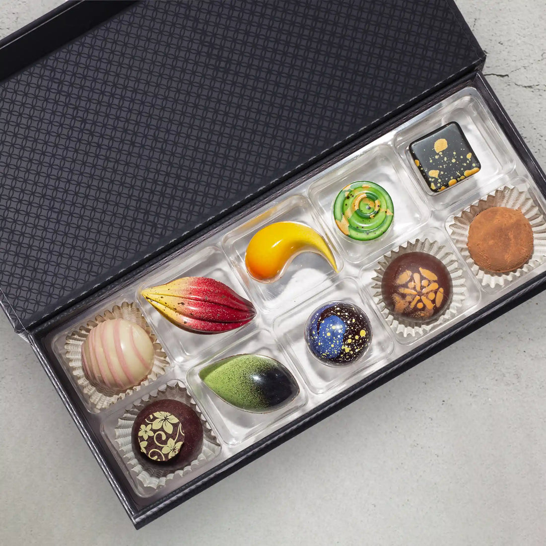 Amore Luxury Chocolate Box showing the 10 bonbons and truffles in front of a closed gift box