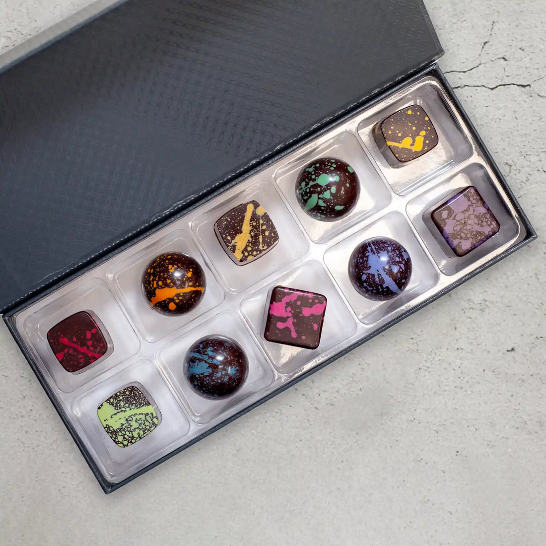 Iridia Elite chocolate gift box with 10 pieces of sugar free dark chocolates with a rainbow of splattered paint
