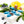 Blueberry Cream teardrop shaped dark chocolate bonbon with blue coloring and green stripes, filled with blueberry and white chocolate ganache on a white table with blueberries and basil leaves