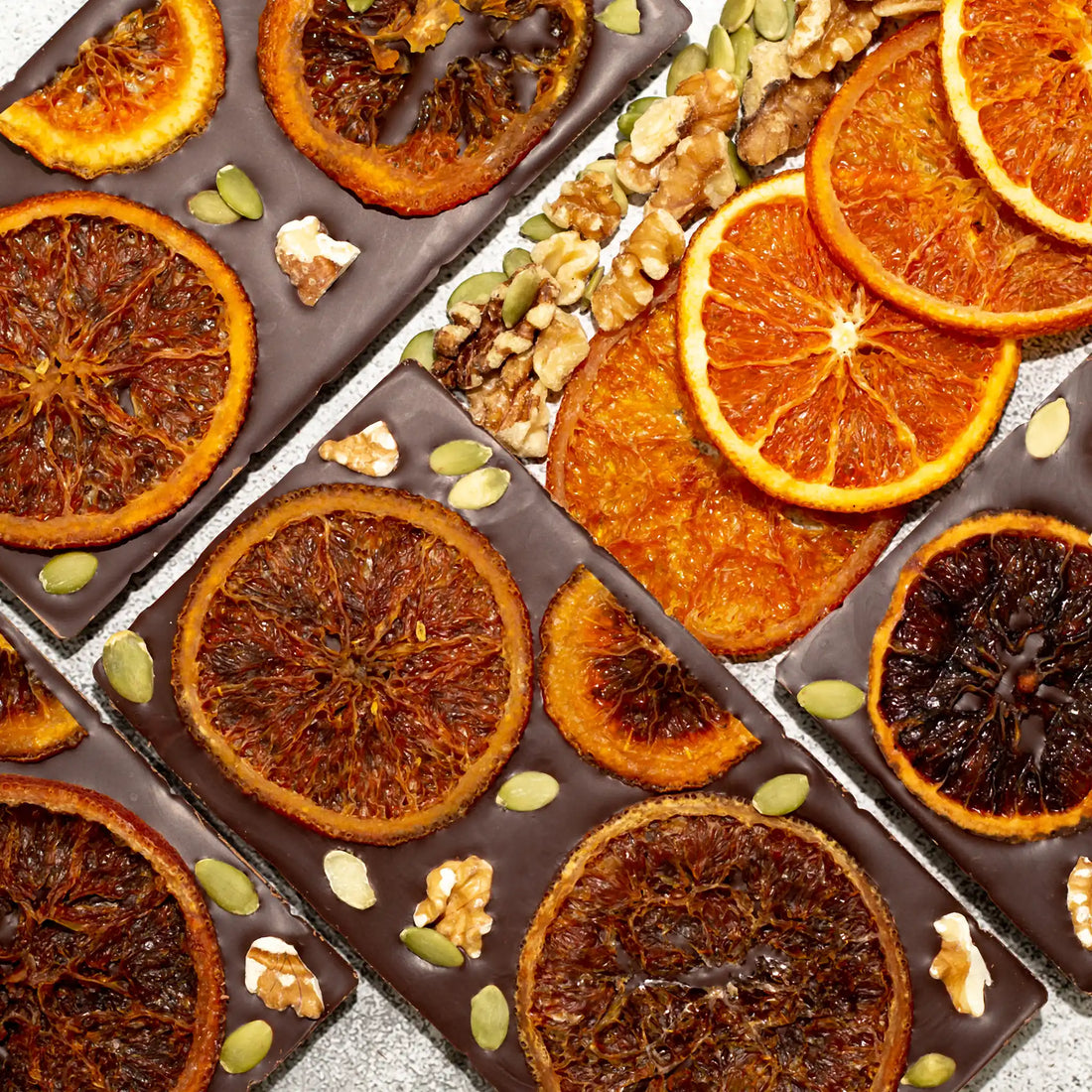 Happiness Dark Chocolate Bar with the front showing a hexagon pattern and the back with caramelized oranges, walnuts, and pumpkin seeds