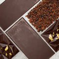 Noir Dream dark chocolate bar showing front with geometric pattern and gold flakes and smooth back side