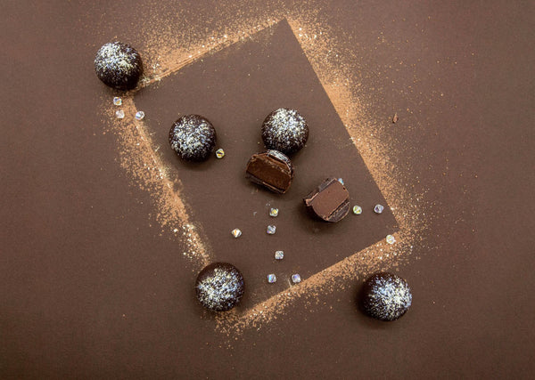 Ginger Truffles on a brown background, showing creamy milk chocolate ganache center