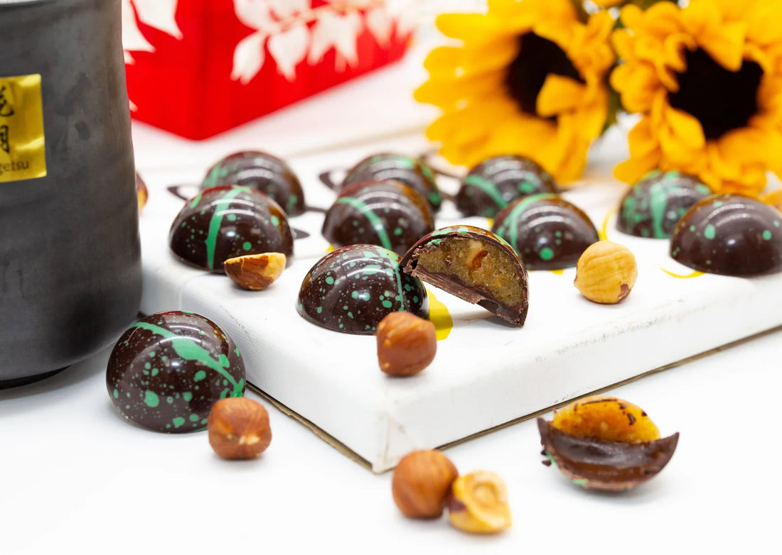 Hazelnut Praline sugar free dark chocolate dome-shaped bonbon with green splattered paint