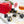 Irish Cream dark chocolate bonbons with orange splattered paint and Baileys creamy filling, on a white table next to a red gift box and whiskey cocktail