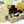 Lemon Curd dark chocolate bonbons with yellow splattered paint and creamy yellow lemon filling on a white table with sliced lemon and pear