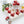 Red heart-shaped Lychee Bloom dark chocolate bonbons with creamy lychee white chocolate filling on a white table with white flowers