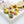 Pear Caramel pear-shaped dark chocolate bonbons with yellow, green, and red coloring and a pear jam caramel filling on a white table with sliced pear