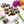 Rosemary Mango dark chocolate bonbons splattered with orange coloring and creamy yellow mango filling on a white table with rosemary leaves, flowers, and a mango