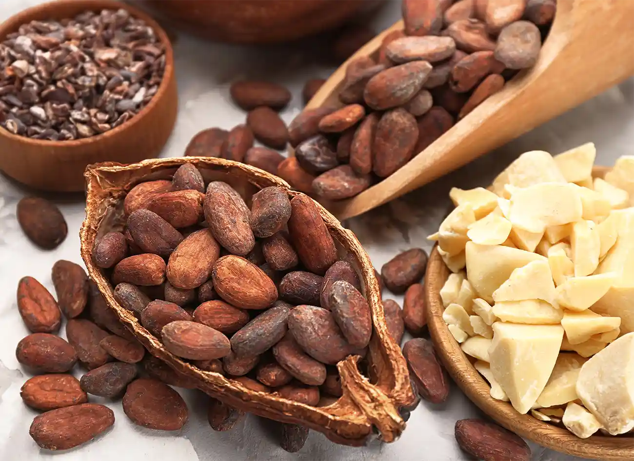 Cacao beans and cacao butter in wooden bowls